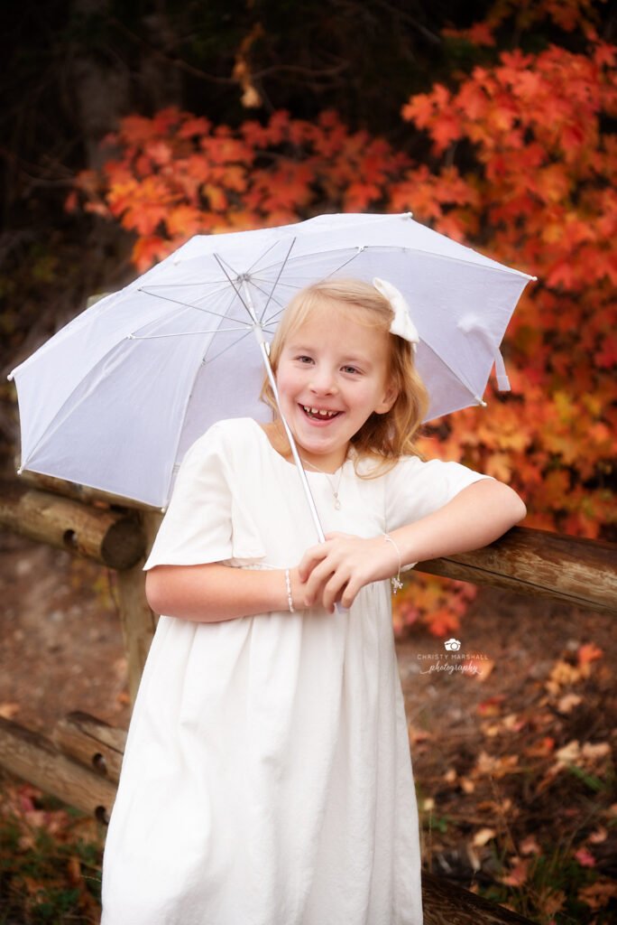 young girl in white dress with white umbrella