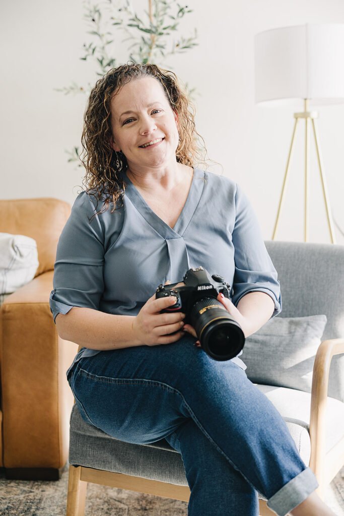 Picture of women sitting in a chair holding a camera