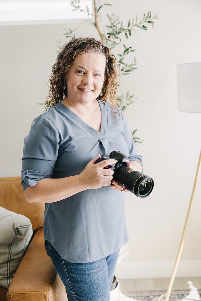 woman in blue shirt holding a camera